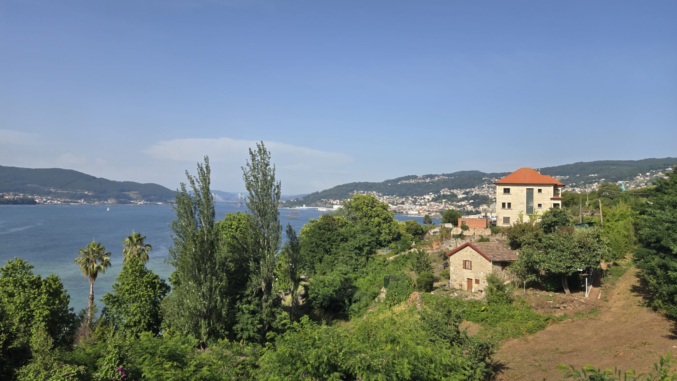 Scenic view of Galicia with lush greenery and a river under a clear blue sky.