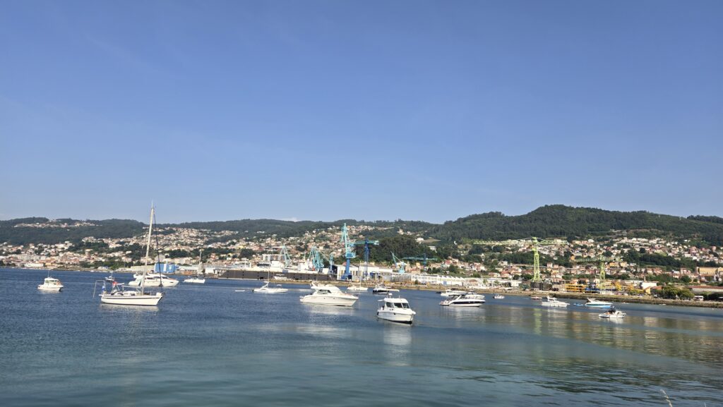 Scenic view of Vigo's harbor with boats and cityscape in the background.