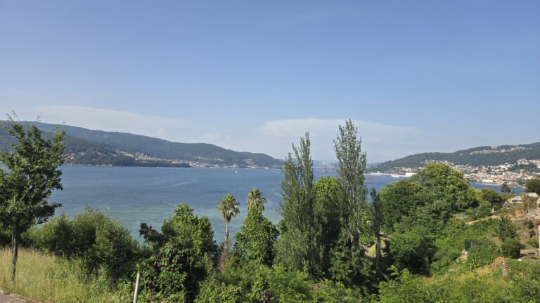 Scenic view of a lake with lush green trees and hills in the background.