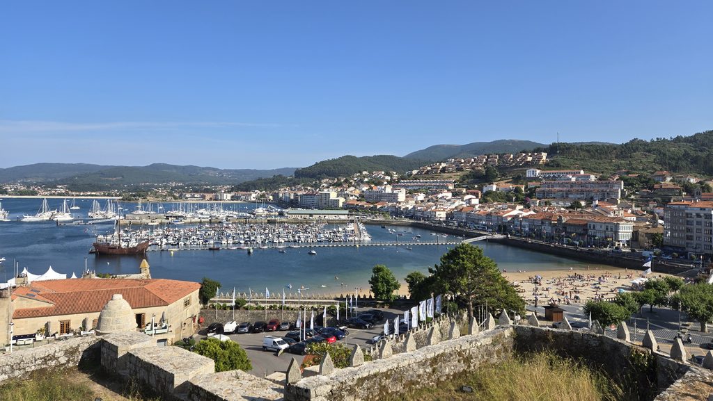 Scenic view of a coastal city with a marina and historic stone walls.